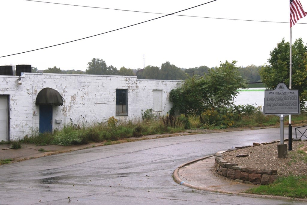 An old block building overgrown with weeds.